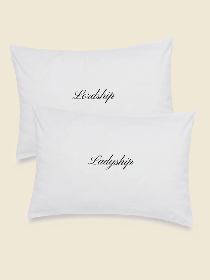 white pillowcase set with embroidered words in black saying Lordship and Ladyship