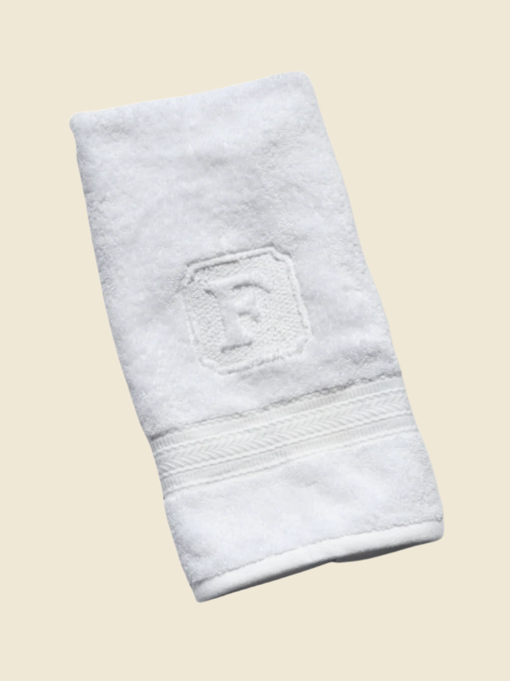 White hand towel with a textured border on a white background