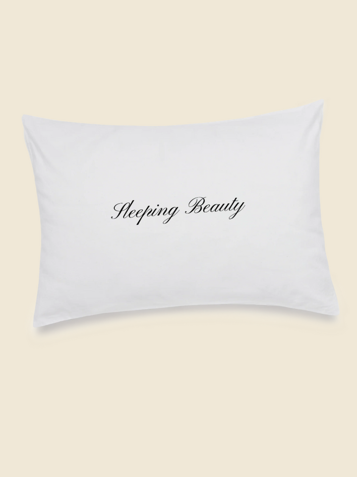 white pillowcase with black embroidered text saying sleeping beauty in the centre