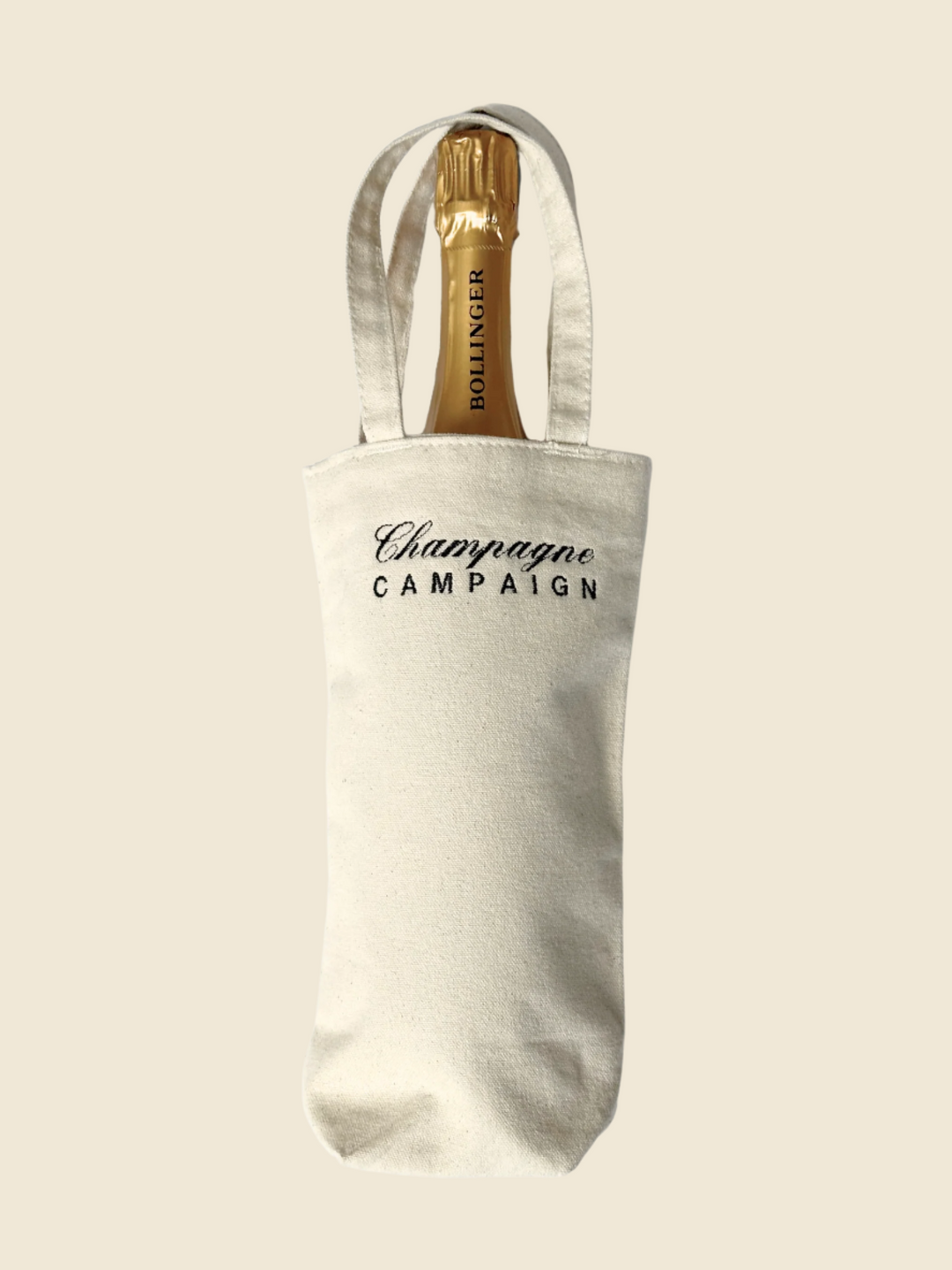 canvas bag with embroidered text and bottle of champagne