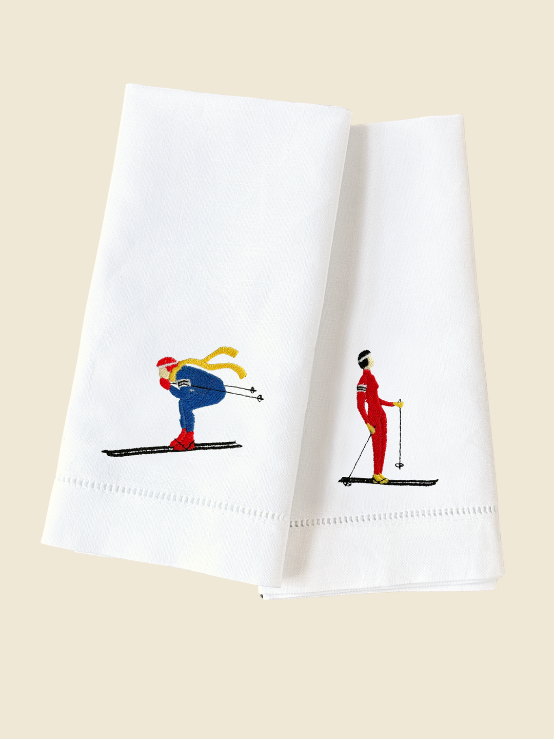 White handkerchiefs with embroidered skiers on a beige background